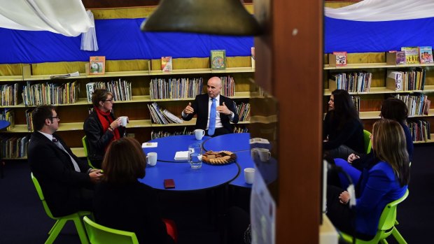 Education Minister Adrian Piccoli speaks to the principal and teachers at Villawood North Public School amid concerns about funding.
