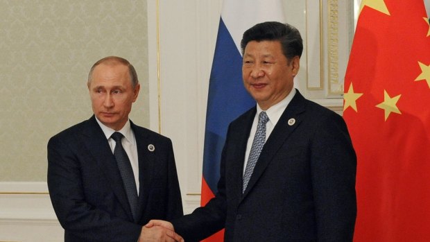 Russian President Vladimir Putin, left, and Chinese President Xi Jinping shake hands during their meeting at a summit in Tashkent, Uzbekistan.