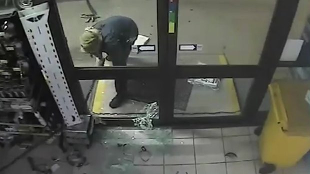 A man chains up an ATM inside the service station.