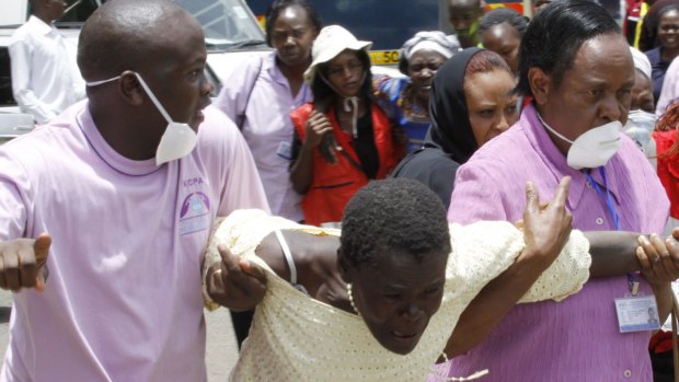 Medical staff console a woman in Nairobi after she viewed the body of a relative killed in Thursday's attack at Garissa University in north-eastern Kenya.