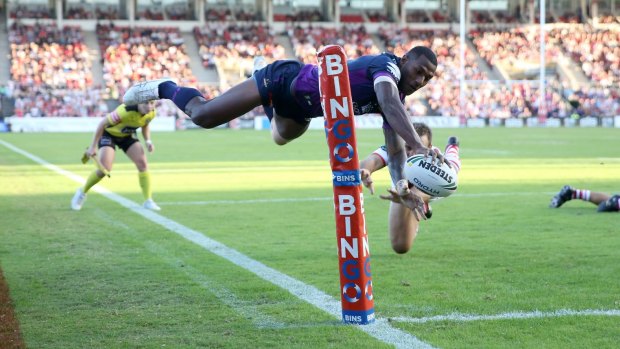 Flying high: Melbourne winger Suliasi Vunivalu gets airborne to score against the Dragons.