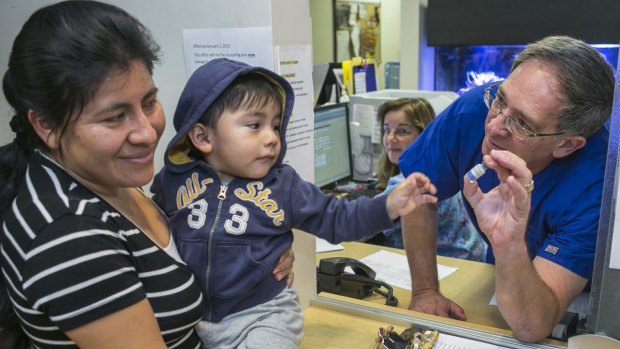 Pediatrician Charles Goodman, talks with patient Carmen Lopez, holding her 18-month-old son, Daniel, after being vaccinated with the measles-mumps-rubella vaccine in Northridge, California.