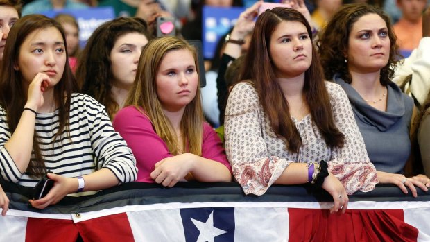 Young women listen to first lady Michelle Obama speak during a campaign rally for Democratic presidential candidate Hillary Clinton.