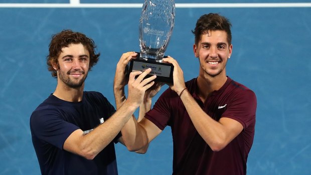 Unexpected victory: Jordan Thompson and Thanasi Kokkinakis hold the winners trophy on day eight of the Brisbane International.