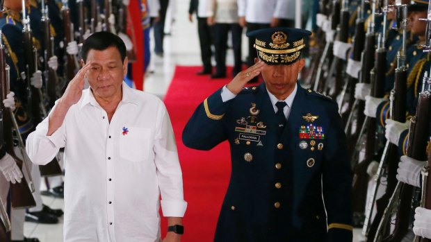 Philippine President Rodrigo Duterte salutes the honour guard.