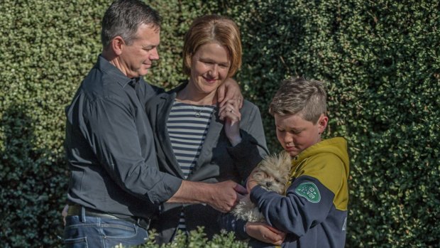 Sarah and Tom McGoram, with son George,10, and dog Winston in the yard of their Gungahlin home.