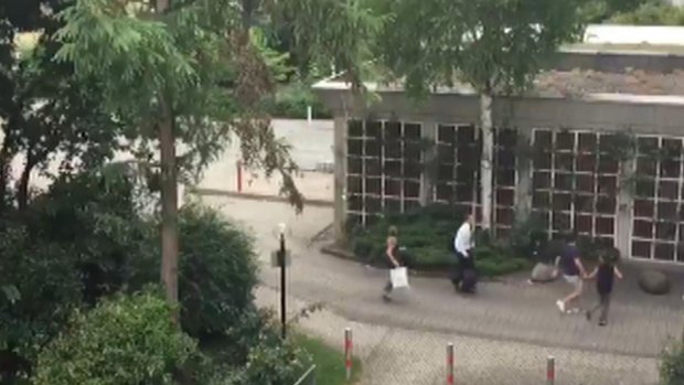 In this frame grab taken from video, people run from the  Olympia Einkaufszentrum shopping centre after a shooting, in Munich.