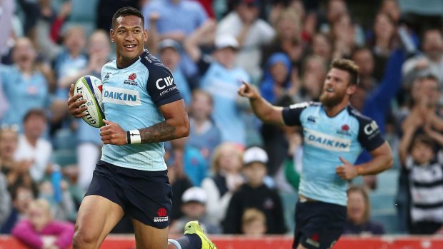 All smiles: Israel Folau scores for the Waratahs during a 50-23 thumping of the Melbourne Rebels.