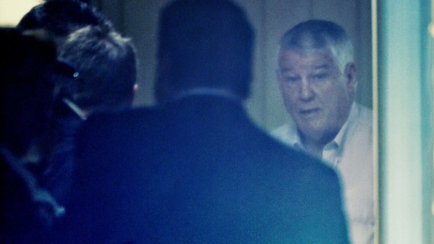 Wayne Beavis inside his house as it is raided by the NSW fraud squad.
