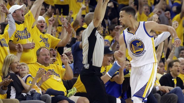 Golden State Warriors' Stephen Curry  celebrates his three-point basket with the crowd.