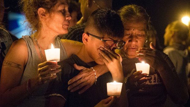 Mona Rodriguez holds her 12-year-old son, J Anthony Hernandez, during a candlelight vigil held for the victims of a fatal shooting at the First Baptist Church of Sutherland Springs.