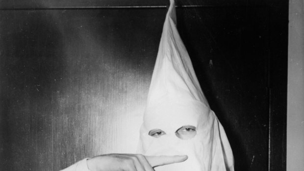 Stetson Kennedy, author of the Ku Klux Klan (KKK) study Southern Exposure, posing in the Klan's uniform to illustrate the sign indicating the Oath Of Secrecy in 1947.