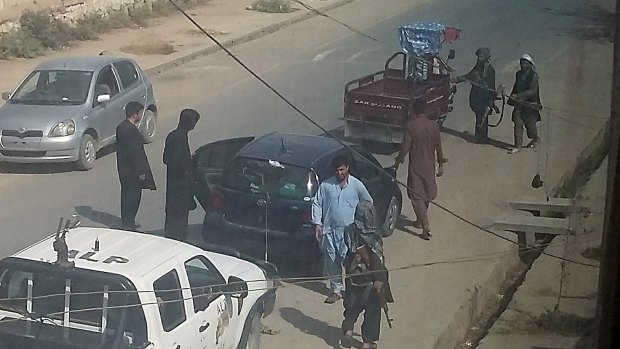Taliban fighters search passengers and civilian vehicles in a check point in Kunduz.