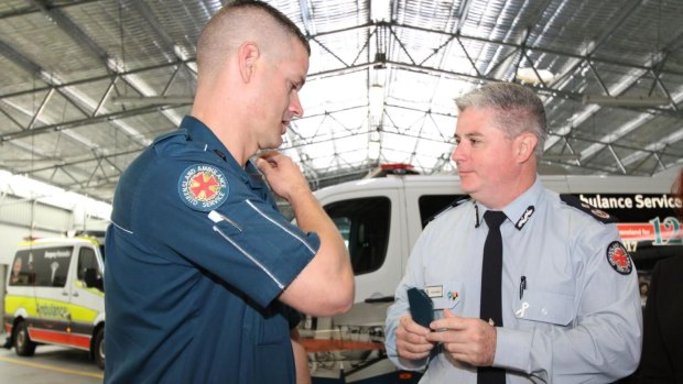 Indigenous-Australian paramedic Dwayne Simpson receives his first-year white stripe from Acting Commissioner Craig Emery.