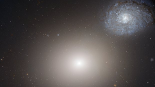 In the centre, a slow-spinning galaxy. On the right, a faster-spinning galaxy has spread into an elegant spiral.