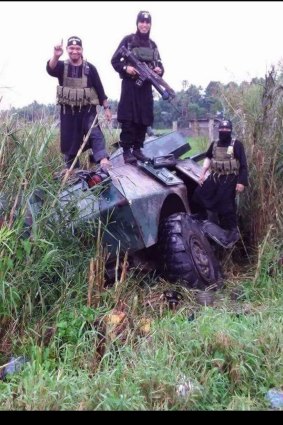 Militants in Marawi stand on an armoured vehicle they seized during four days of fighting in this exclusive photo from the besieged city. .