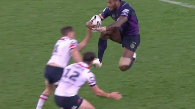 'How do you comment on that?' Melbourne's Suliasi Vunivalu leaps with his knees at the Roosters defenders.
