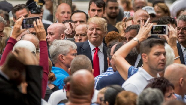 Republican presidential candidate Donald Trump smiles for the cameras at the New York 9/11 memorial service.