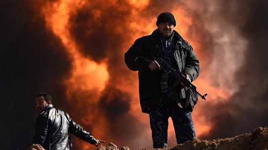 QAYYARAH OIL WELL FIRES Two men provide security at Well 77 in the Qayyarah oil fields. When ISIS retreated from the Iraqi town of Qayyarah they set fire to the oil wells sending plumes of toxic black and white smoke that blanket the sky. Since October 2016 as many as 1,000 people have been hospitalized with respiriatory illnesses caused by inhaling the fumes. The impact has also affected the environment and sheep herds causing many to die and turning their wool black from the soot. Qayyarah, Northern Iraq. 3rd February, 2017. Photo: Kate Geraghty