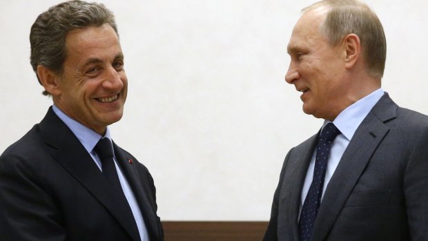 All smiles: Russian President Vladimir Putin, right, and former French president Nicolas Sarkozy greet each other.