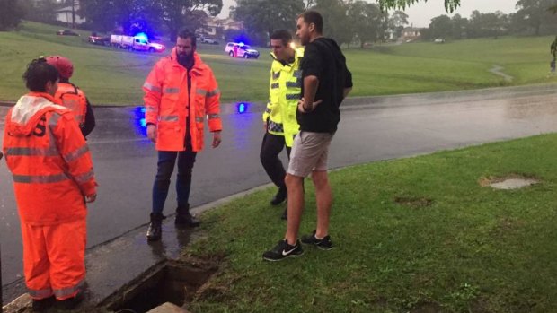 A search team at a drain in Riley Park on Thursday.