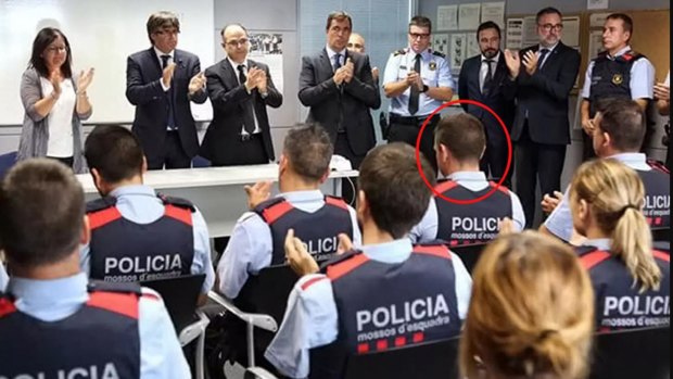 Colleagues burst into spontaneous applause for the officer (circled) at a ceremony.