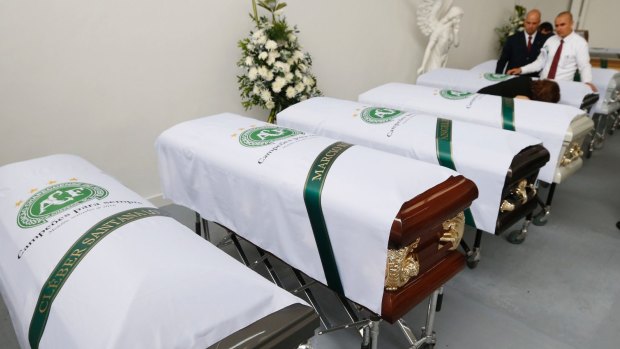 White sheets with the Chapecoense team logo cover coffins containing the remains of team members.