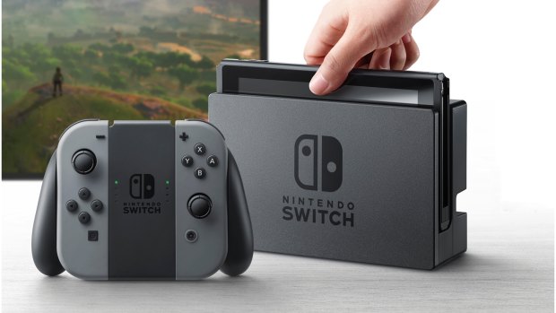 The Switch console is pictured here in its TV dock. The left and right controller modules, pictured here attached to the grip in the foreground, can also be attached to the console itself for on-the-go gaming.