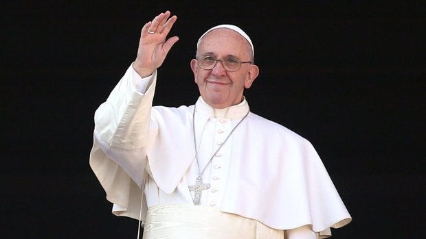 Pope Francis waves to the faithful as he delivers his "Urbi et Orbi" blessing message from the central balcony of St Peter's Basilica at Christmas.