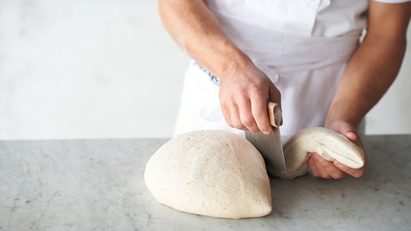 Shaping the dough step 1: Once the dough is ready to be shaped, take a bench scraper and cut off a piece from the edge.