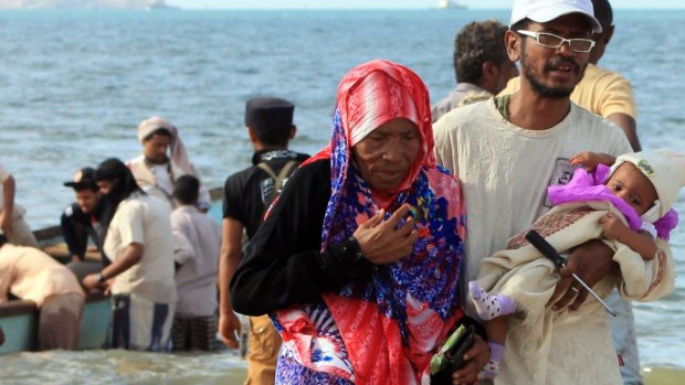 Yemenis walk on a beach of Aden's Tawahi neighbourhood on Wednesday as civilians try to escape the fighting by sea.