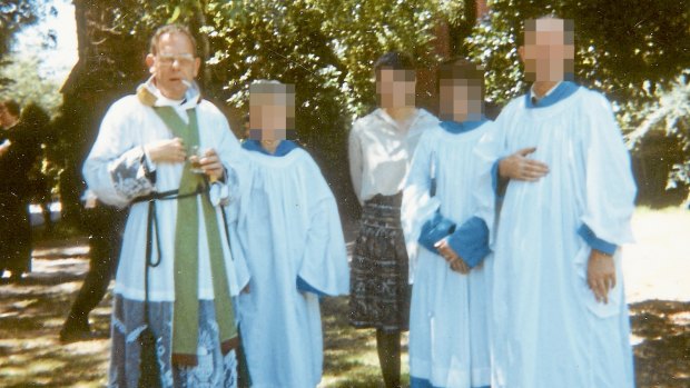 Father Ronald Pickering [L] with choir.