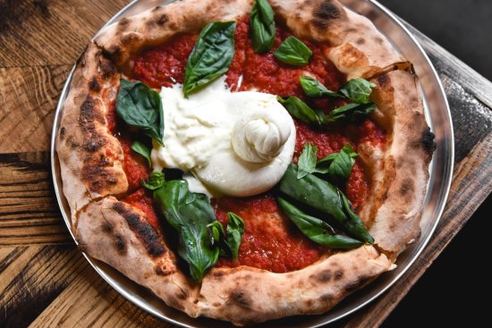Burrata, tomato sugo and fried basil pizza from the wood-fired oven.