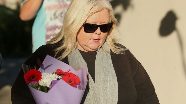 A woman delivers flowers to the Ristevskis' home on Tuesday.