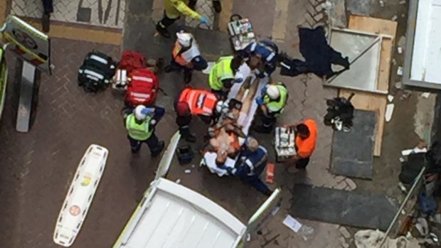 Paramedics take a worker from a North Sydney building site to hospital after a crane collapse. 