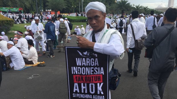 A protester carries a sign that reads "The people of Indonesia do not need Ahok" at a December rally against the governor in Jakarta.