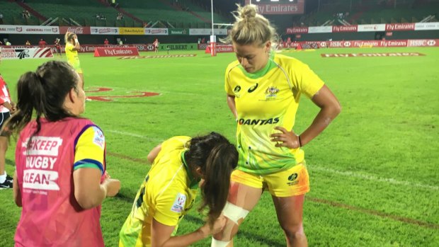 Australian women's sevens player Brooke Anderson receives emergency treatment from teammates Alicia Quirk and Chloe Dalton at the Dubai sevens world series tournament on Dec 1.