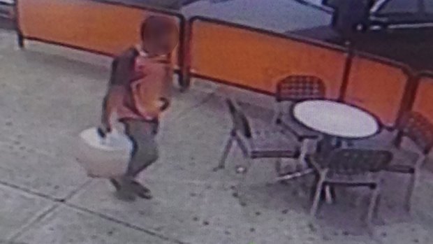 CCTV footage showing a man walking back to the bank with a container after he visited a service station. 