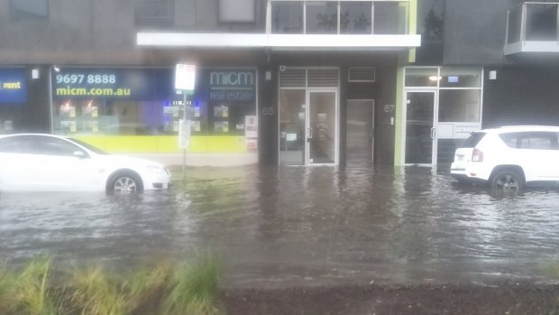 Water laps the doorways of several buildings on City Road, Southbank, as a series of slow moving storms hit the city.