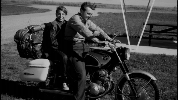 Robert M. Pirsig and his son Chris riding a motorcycle on a journey that was later documented in Pirsig's 1974 book, <em>Zen and the Art of Motorcycle Maintenance</em>.