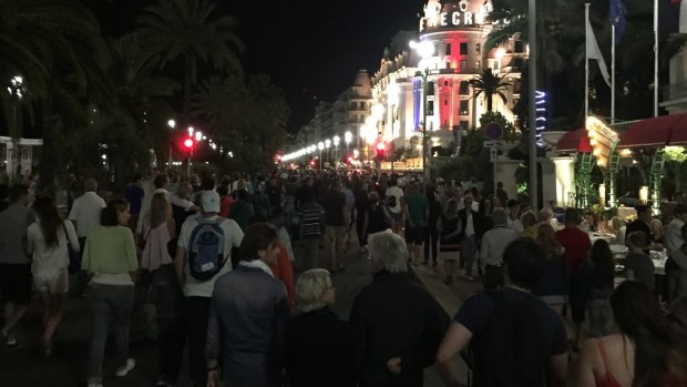 Crowds walk down the Promenade des Anglais moments before a truck fatally hits 84 people.
