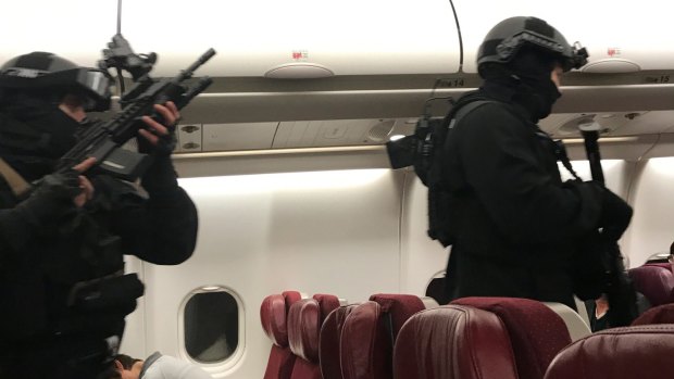Heavily armed police enter the plane.