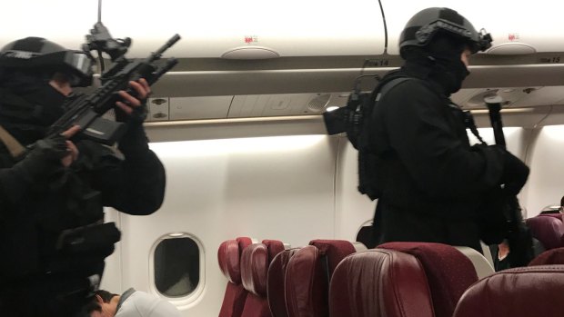 Heavily armed police enter the plane.