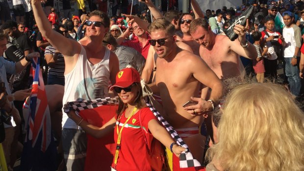 The men pose with revellers at the Malaysian Grand Prix before their arrest for public indecency.