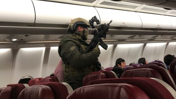 Security personnel board Flight MH128 after it returned to Melbourne.