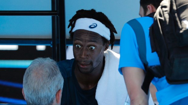 France's Gael Monfils is attended to by a trainer and tournament officials as the heat on court hits 69 degrees.