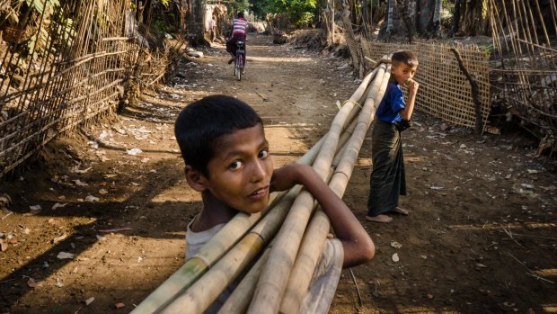 Boys carry bamboo stalks at the Sin Tet Maw camp for internally displaced persons in Rakhine State, Myanmar.