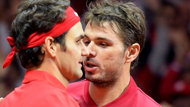 Friends again: Roger Federer and Stan Wawrinka embrace after winning the doubles against France.