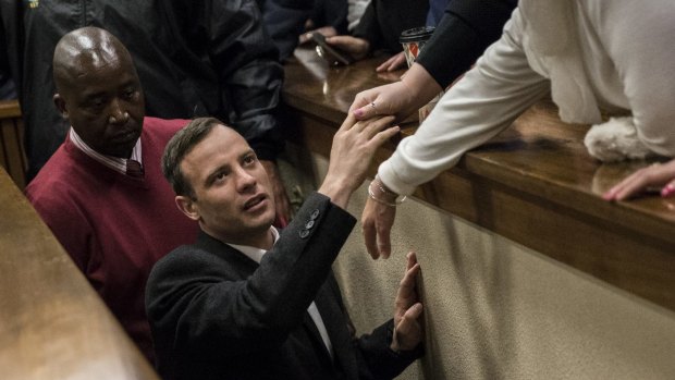 Oscar Pistorius holds the hand of a relative after his sentencing.