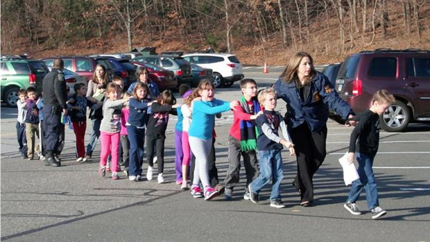 State police personnel lead children from Sandy Hook Elementary School three years ago.